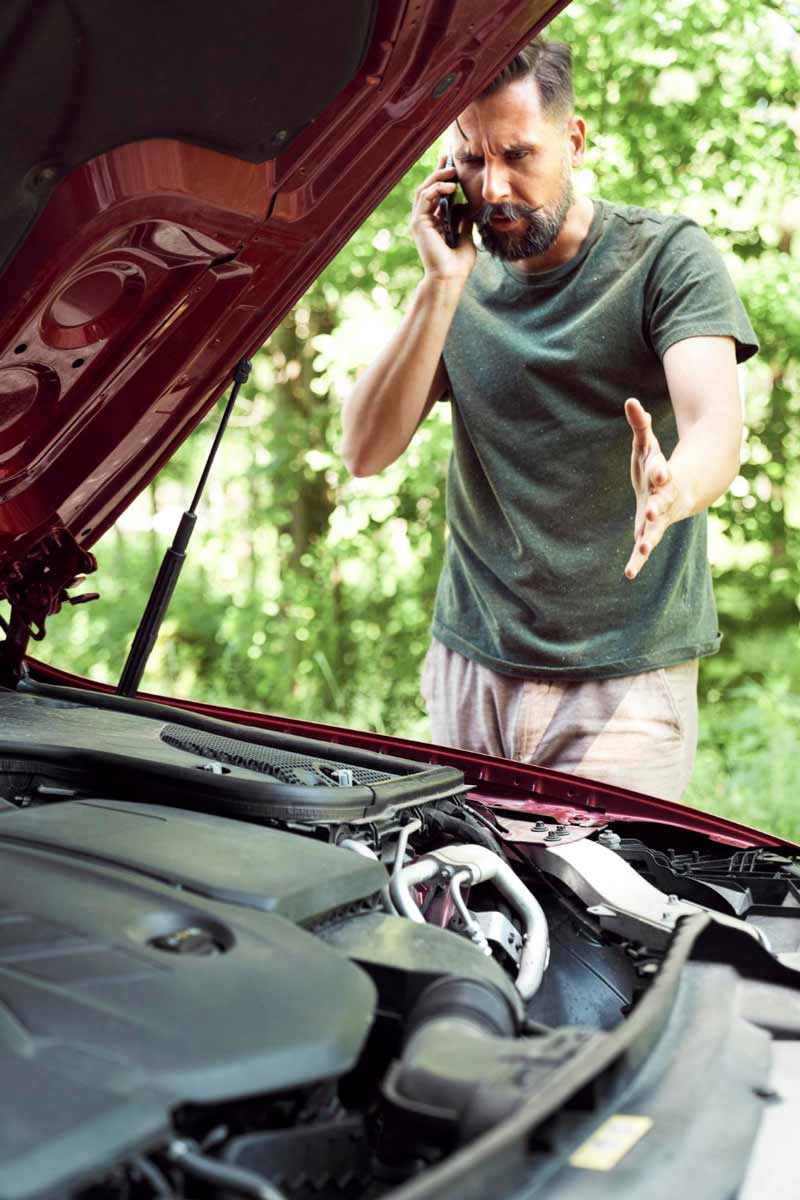 Junger Mann prüft Getriebeschaden bei Schrottauto Ankauf Frechen